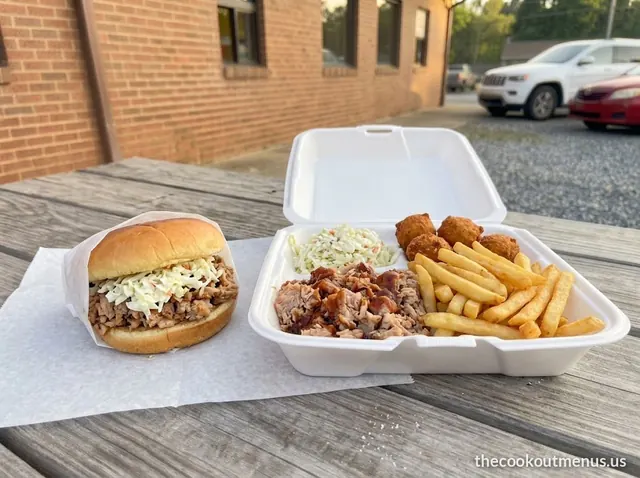 Chopped pork BBQ sandwich with slaw next to a BBQ plate with slaw, fries and hushpuppies