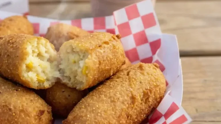 Golden Cookout hushpuppies in a red checkered paper basket, one broken open