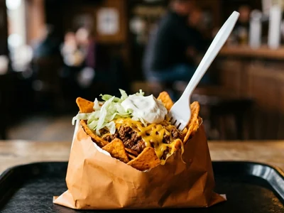 Cookout Walking Taco with chili, cheese, lettuce and sour cream in a paper bag